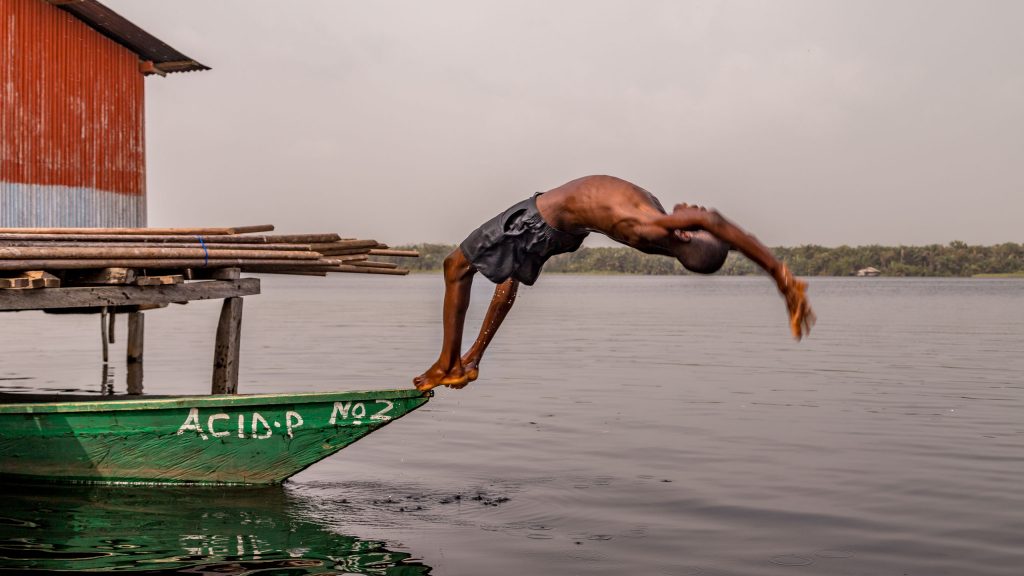Backwards dive boy - GHANA - Stilt village Nzulezo on lake Tadane (Beyin); day trip from Takoradi