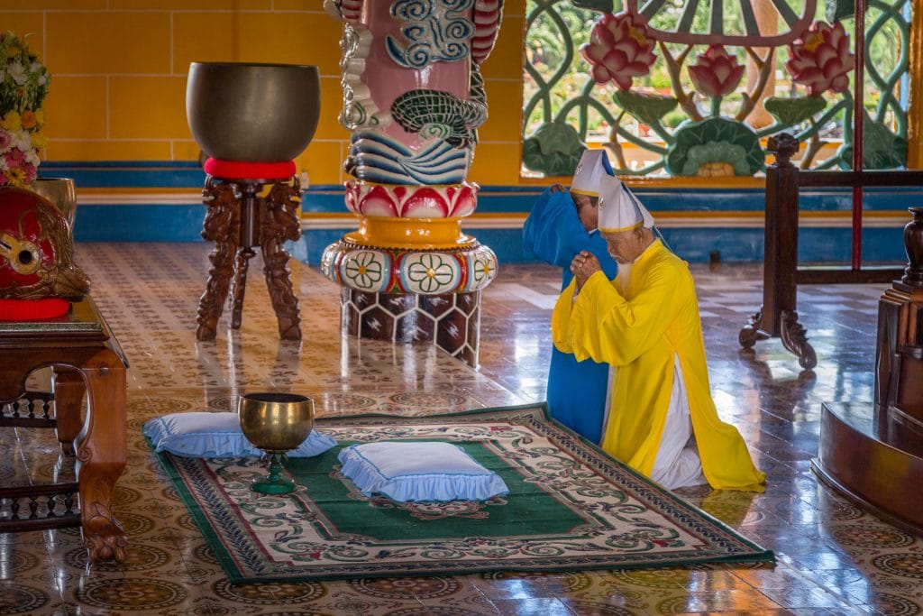 Yellow Blue Priest Praying - VIETNAM - Must do day trip: Cu Chi tunnels and Cao Dai Temple from Ho Chi Min City